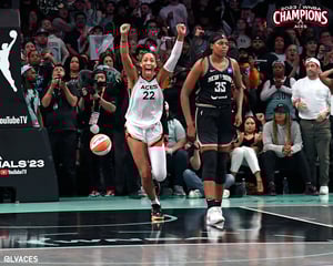 Las Vegas Aces’ star A’ja Wilson celebrates the team's title win beside a visibly sad Jonquel Jones of the New York Liberty.